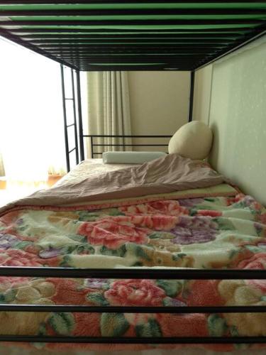 长野「けったもん」へようこそ！2階の1室でゆっくり休めます！的卧室里的一张床铺,上面有花毯