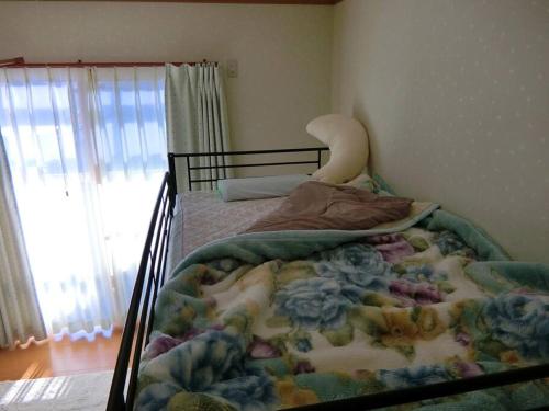 长野「けったもん」へようこそ！2階の1室でゆっくり休めます！的卧室里的一张带毯子的床