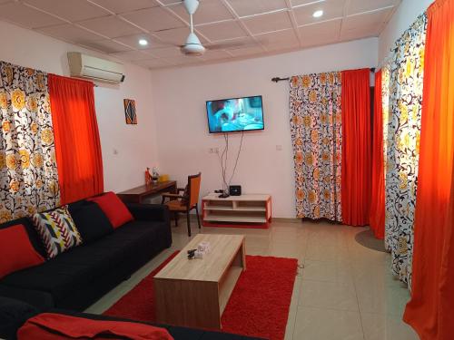 瓦加杜古AKD Résidence et Automobile的客厅配有红色窗帘和沙发