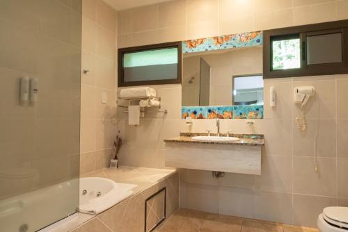 伊瓜苏港卡塔拉塔斯乡村酒店的一间带浴缸、水槽和镜子的浴室