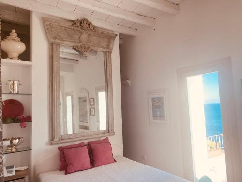 莫诺波利B&b Casa Maredentro的白色的客房配有镜子和红色枕头