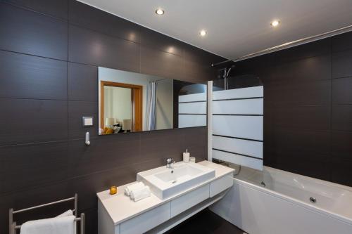 里斯本Apartamento Lisboa Sete Rios的浴室配有盥洗盆、镜子和浴缸