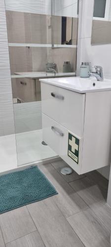 里斯本Chinde Guesthouse的白色的浴室设有水槽和镜子