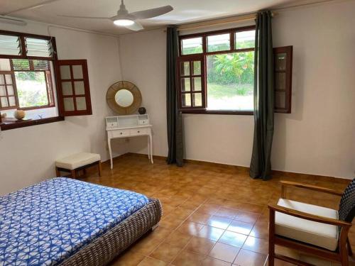 GourbeyreZayann Zen的卧室配有床、桌子和窗户。