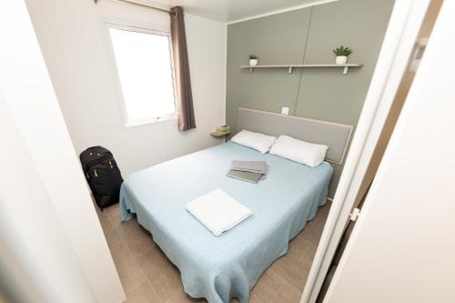 皮内达德马尔Camping Bellsol Pets的一间卧室配有一张带蓝色毯子的床和窗户。