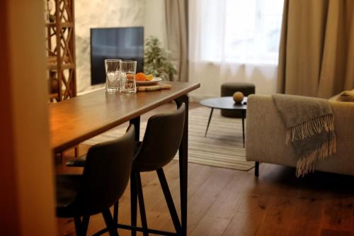 塔林Town Hall Square Apartment的客厅配有木桌和椅子