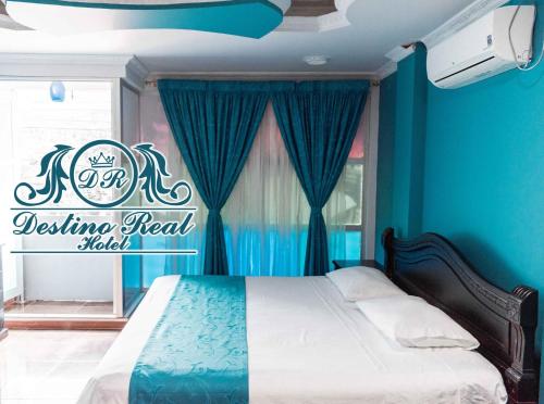 阿劳卡Destino real hotel的一间卧室配有一张蓝色墙壁的床和一扇窗户