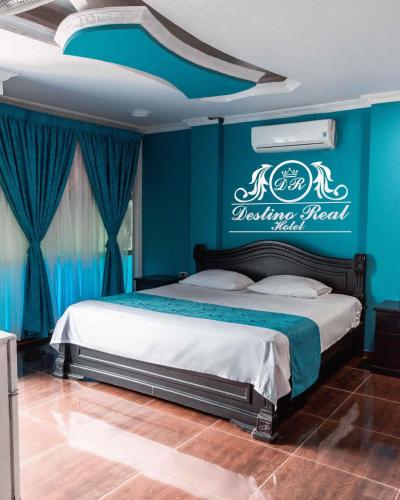 阿劳卡Destino real hotel的一间卧室配有一张蓝色墙壁的床