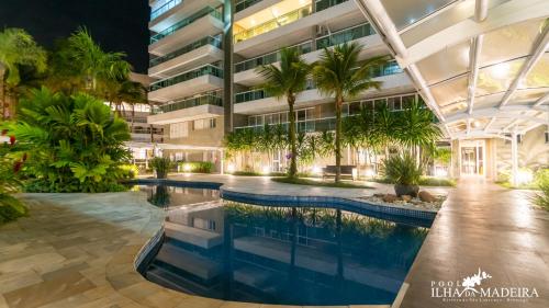 圣劳伦斯海滨Pool Ilha da Madeira Resort的一座带游泳池和棕榈树的办公楼