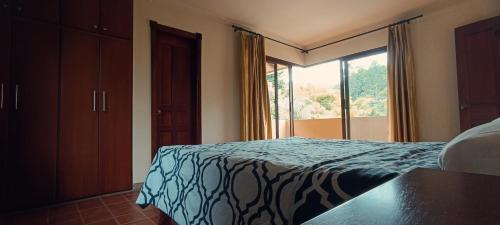 洛哈La Rivera Chamba的一间卧室设有一张床和一个大窗户