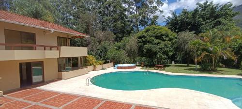 洛哈La Rivera Chamba的房屋前的游泳池