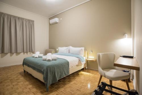 特尔斐V Hotel Delphi的一间卧室配有一张床、一把椅子和一张书桌