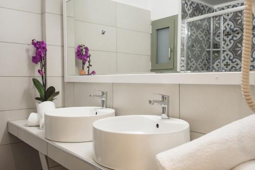 特尔斐V Hotel Delphi的白色浴室内的两个水槽,带紫色花卉