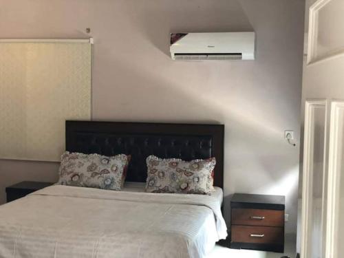卡拉奇Hotel Sky Inn Clifton的一间卧室配有一张带黑色床头板的床