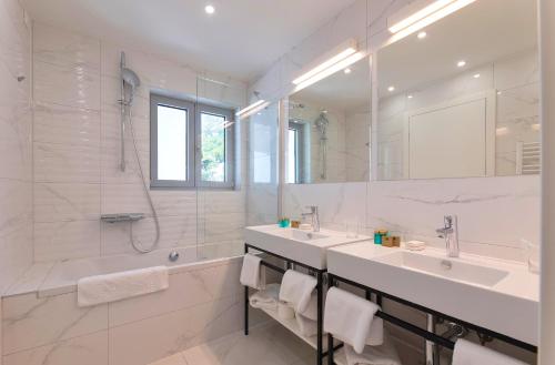 奥米什Hotel Saint Hildegard的白色的浴室设有2个盥洗盆和淋浴。