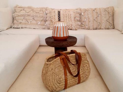 马拉喀什Riad Nour, Maison de charme.的一张桌子,一张沙发旁边装着袋子