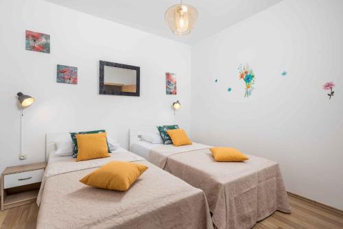 克拉列维察Two-Bedroom Apartment in Kraljevica II的白色客房的两张床,配有黄色枕头
