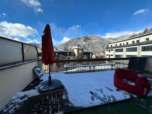 奥尔迪诺appartement Terrasse 1 chambre ORDINO HUT3-008298的阳台配有红色遮阳伞和雪。