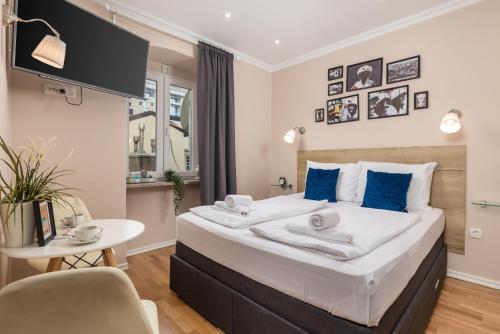 里耶卡Apartments Neo的一间卧室配有一张带蓝色枕头的大床