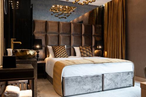 克拉科夫Art Suites Luxury Hotel的一间带大床的卧室和一间浴室