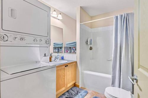 坎莫尔Canmore Mountain view loft apartment heated outdoor pool的一间带水槽、浴缸和卫生间的浴室