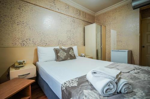 伊斯坦布尔SAHRA OTEL的一间卧室配有带毛巾的床