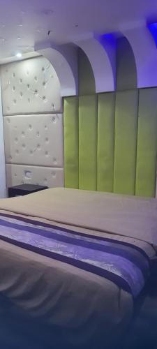 勒克瑙S R HOTEL & RESTAURANT的一间卧室设有一张带绿色和白色墙壁的床。