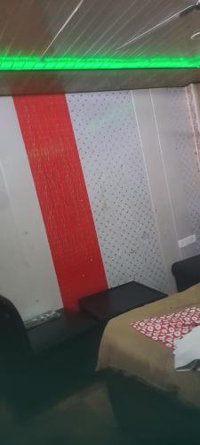勒克瑙S R HOTEL & RESTAURANT的一间设有一张红色和白色墙壁的床的房间