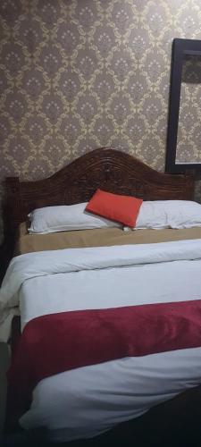 勒克瑙S R HOTEL & RESTAURANT的一间卧室配有一张红色枕头的床