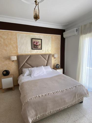 Dar el BeïdaHostel Apart的一间卧室设有一张大床和一个大窗户