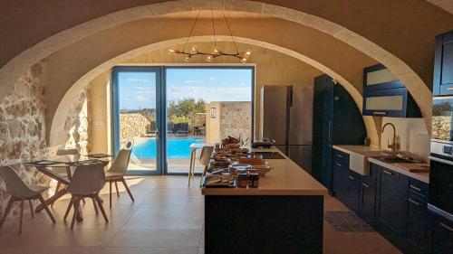 纳杜尔Sea Holly Gozo的一间带桌子的厨房和一间带游泳池的用餐室