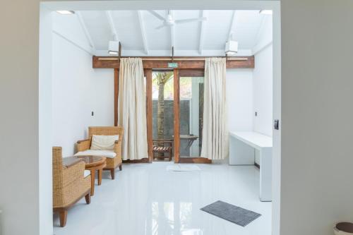 拉斯杜Brickwood Ganduvaru Private Villas的带沙发和椅子的客厅以及窗户。