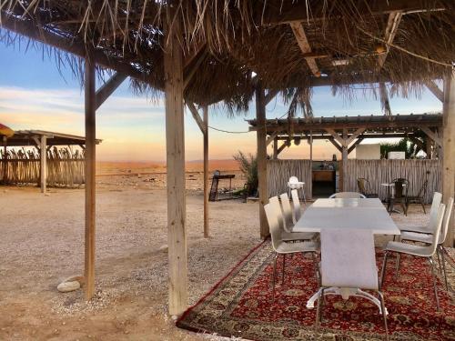‘Ezuz内格夫托比纳沙漠旅馆的海滩小屋下的桌椅