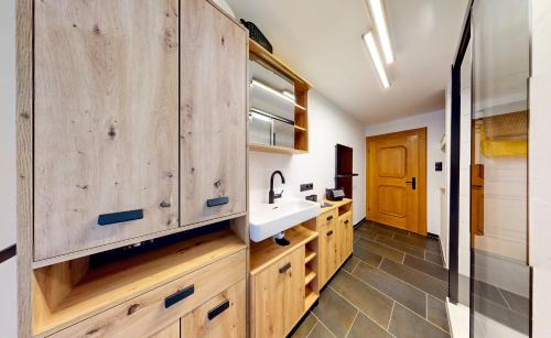 厄茨Ferienhaus Hennewinkl的一个带木制橱柜和水槽的厨房