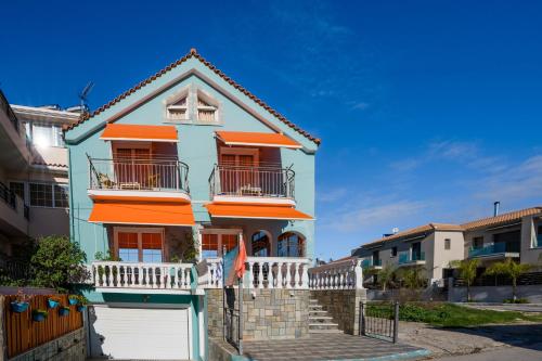 里科索翁Belleza Villa的蓝色和橙色的房子,设有白色车库
