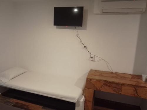 曼萨尼约埃斯孔迪多酒店的一间设有床铺和墙上电视的客房