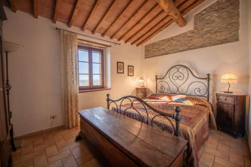 PariAgriturismo Antico Borgo Montacuto的一间卧室配有一张床和一张木桌