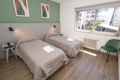 圣卡洛斯-德巴里洛切M382 Hotel Bariloche的酒店客房设有两张床和窗户。