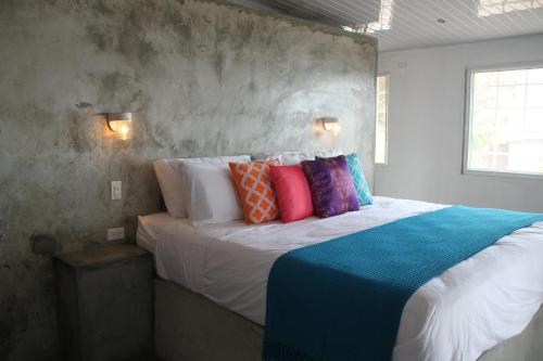 普拉亚科罗纳多La Maracuya Panama的一间卧室配有一张带色彩缤纷枕头的大床