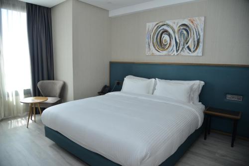 卡萨布兰卡Privilège Oasis Hôtel的一间卧室配有一张大床和蓝色床头板