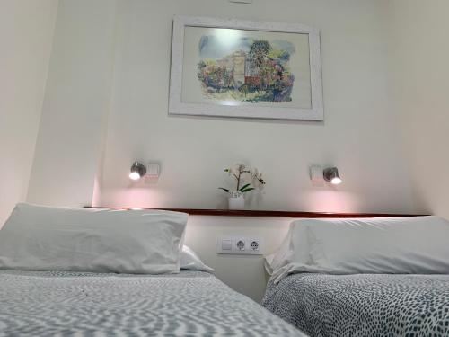 圣玛丽亚港Apartamento La Vasca的卧室配有两张床,墙上挂着一幅画