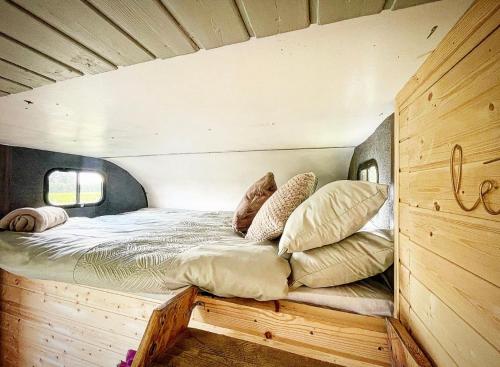 约克North Yorkshire Horse Box的木制房间内的一张床位,配有枕头