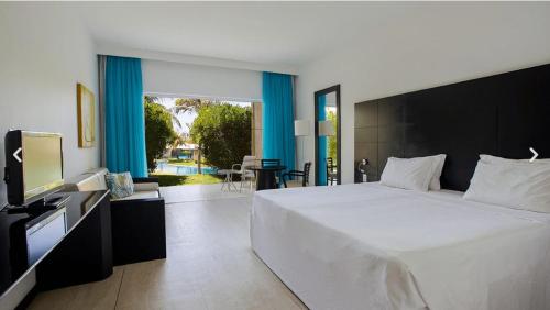 福塔莱萨Dom Pedro Laguna Beach Resort & Golf的卧室配有一张白色大床和电视。