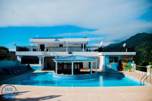 海地角J&G Villa Hotel的一座大房子,前面设有一个游泳池