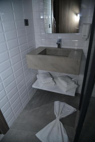 卡萨布兰卡Privilège Oasis Hôtel的浴室设有水槽和一堆毛巾