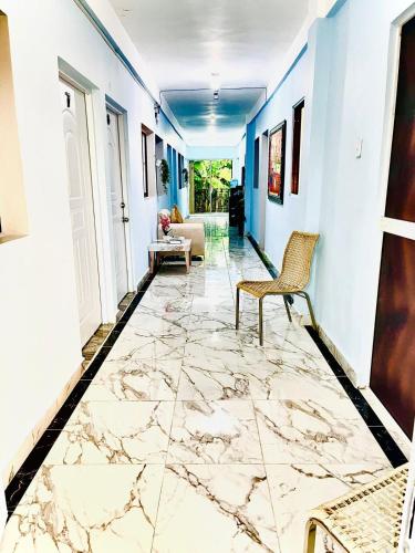 巴拉奥纳省圣克鲁斯Neo’s hotel的走廊设有大理石地板和椅子