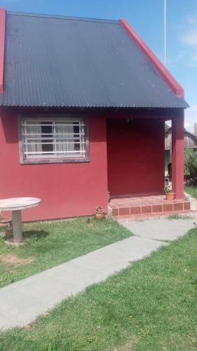 San RoqueLa Morada的一间红色的房子,前面设有一张野餐桌