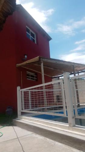 San RoqueLa Morada的红色房子前面的白色围栏