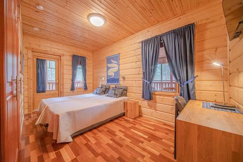 列维Levi President的木制客房内的一间卧室,配有一张床