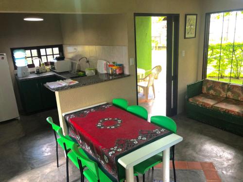 塔曼达雷Chalé Verde的厨房配有带绿色椅子的桌子和台面